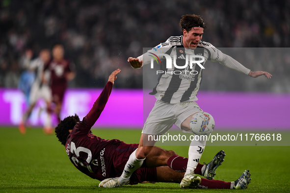 Saul Coco of Torino battles for the ball with Dusan Vlahovic of Juventus during the Serie A match between Juventus and Torino FC at Allianz...