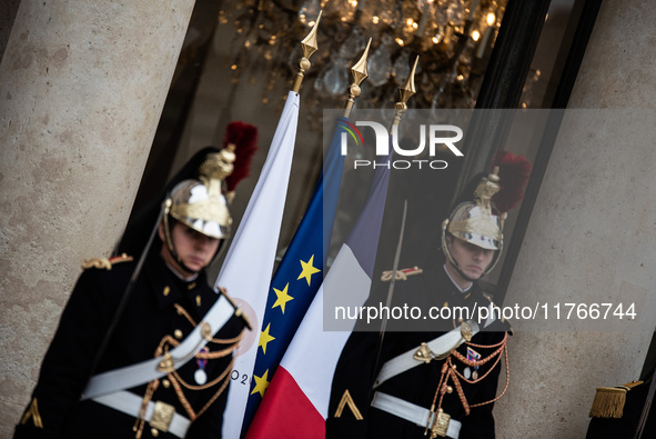 Presidential guards stand at the Elysee Palace with the French and European flags on the occasion of the celebrations for the 106th annivers...