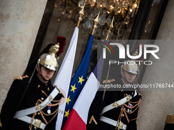 Presidential guards stand at the Elysee Palace with the French and European flags on the occasion of the celebrations for the 106th annivers...