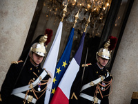 Presidential guards stand at the Elysee Palace with the French and European flags on the occasion of the celebrations for the 106th annivers...