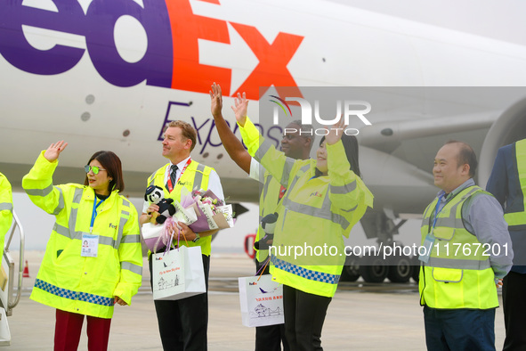 FedEx employees and crew members wave to people as they greet them in Qingdao, China, on November 11, 2024. 