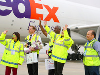 FedEx employees and crew members wave to people as they greet them in Qingdao, China, on November 11, 2024. (