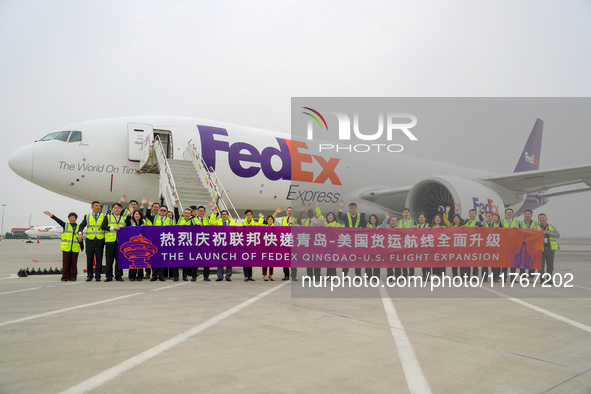 Flight crew members pose for a group photo with FedEx and airport personnel in Qingdao, China, on November 11, 2024. 