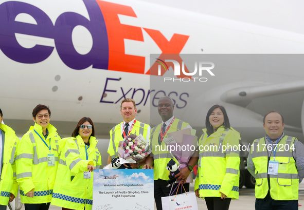 Flight crew members pose for a group photo with FedEx and airport personnel in Qingdao, China, on November 11, 2024. 