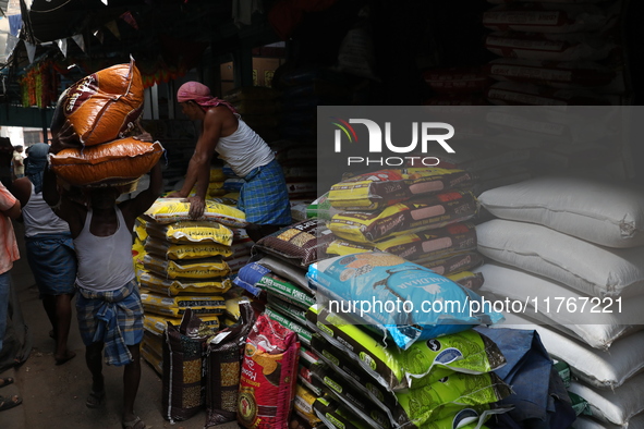 A laborer carries sacks filled with pulses at a wholesale market in Kolkata, India, on November 11, 2024. India's consumer price inflation r...