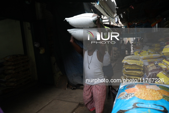 A laborer carries sacks filled with pulses at a wholesale market in Kolkata, India, on November 11, 2024. India's consumer price inflation r...