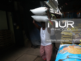 A laborer carries sacks filled with pulses at a wholesale market in Kolkata, India, on November 11, 2024. India's consumer price inflation r...