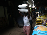 A laborer carries sacks filled with pulses at a wholesale market in Kolkata, India, on November 11, 2024. India's consumer price inflation r...