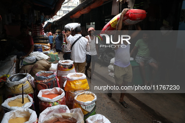 A laborer carries a sack filled with pulses at a wholesale market in Kolkata, India, on November 11, 2024. India's consumer price inflation...