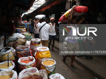 A laborer carries a sack filled with pulses at a wholesale market in Kolkata, India, on November 11, 2024. India's consumer price inflation...