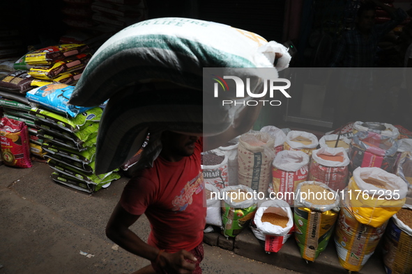 A laborer carries sacks filled with pulses at a wholesale market in Kolkata, India, on November 11, 2024. India's consumer price inflation r...