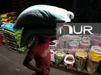 A laborer carries sacks filled with pulses at a wholesale market in Kolkata, India, on November 11, 2024. India's consumer price inflation r...