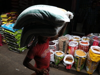 A laborer carries sacks filled with pulses at a wholesale market in Kolkata, India, on November 11, 2024. India's consumer price inflation r...