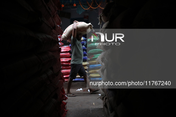 A laborer carries a sack filled with pulses at a wholesale market in Kolkata, India, on November 11, 2024. India's consumer price inflation...