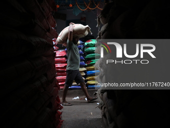 A laborer carries a sack filled with pulses at a wholesale market in Kolkata, India, on November 11, 2024. India's consumer price inflation...