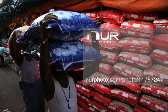 Labourers carry sacks filled with pulses at a wholesale market in Kolkata, India, on November 11, 2024. India's consumer price inflation ris...