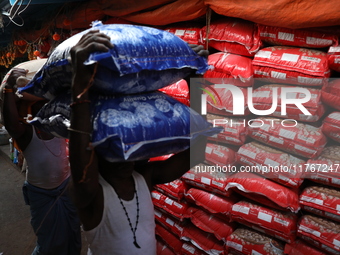 Labourers carry sacks filled with pulses at a wholesale market in Kolkata, India, on November 11, 2024. India's consumer price inflation ris...