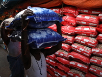 Labourers carry sacks filled with pulses at a wholesale market in Kolkata, India, on November 11, 2024. India's consumer price inflation ris...