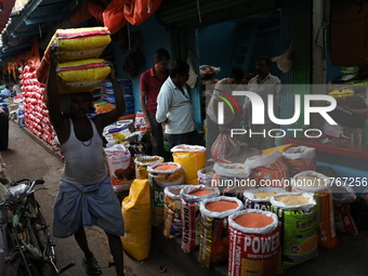 A laborer carries sacks filled with pulses at a wholesale market in Kolkata, India, on November 11, 2024. India's consumer price inflation r...