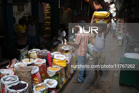 A laborer carries sacks filled with pulses at a wholesale market in Kolkata, India, on November 11, 2024. India's consumer price inflation r...