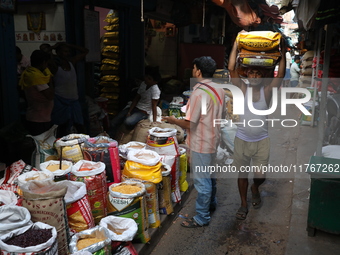 A laborer carries sacks filled with pulses at a wholesale market in Kolkata, India, on November 11, 2024. India's consumer price inflation r...