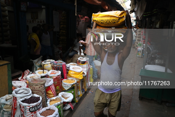 A laborer carries sacks filled with pulses at a wholesale market in Kolkata, India, on November 11, 2024. India's consumer price inflation r...