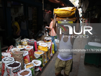 A laborer carries sacks filled with pulses at a wholesale market in Kolkata, India, on November 11, 2024. India's consumer price inflation r...