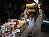 A laborer carries sacks filled with pulses at a wholesale market in Kolkata, India, on November 11, 2024. India's consumer price inflation r...