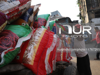 A laborer loads consumer goods onto a supply cart at a wholesale market in Kolkata, India, on November 11, 2024. India's consumer price infl...