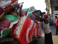 A laborer loads consumer goods onto a supply cart at a wholesale market in Kolkata, India, on November 11, 2024. India's consumer price infl...