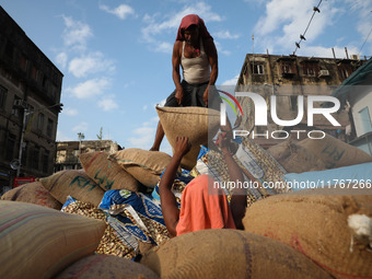 Labourers load consumer goods onto a supply cart at a wholesale market in Kolkata, India, on November 11, 2024. India's consumer price infla...