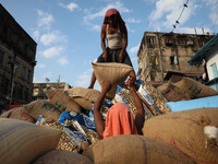 Labourers load consumer goods onto a supply cart at a wholesale market in Kolkata, India, on November 11, 2024. India's consumer price infla...