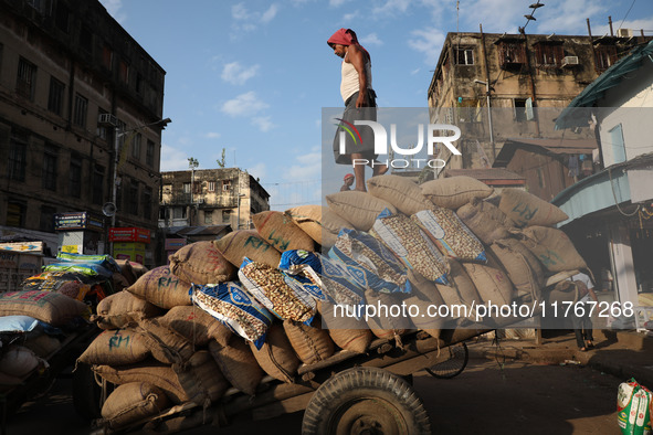 A laborer loads consumer goods onto a supply cart at a wholesale market in Kolkata, India, on November 11, 2024. India's consumer price infl...