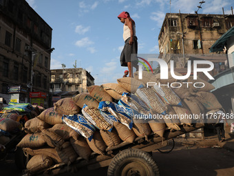 A laborer loads consumer goods onto a supply cart at a wholesale market in Kolkata, India, on November 11, 2024. India's consumer price infl...