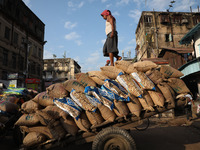 A laborer loads consumer goods onto a supply cart at a wholesale market in Kolkata, India, on November 11, 2024. India's consumer price infl...