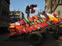 A laborer carries a load of consumer goods onto a supply cart at a wholesale market in Kolkata, India, on November 11, 2024. India's consume...