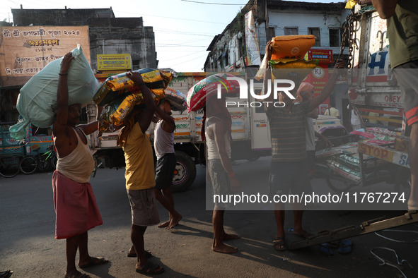 Labourers load consumer goods onto supply trucks at a wholesale market in Kolkata, India, on November 11, 2024. India's consumer price infla...