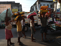 Labourers load consumer goods onto supply trucks at a wholesale market in Kolkata, India, on November 11, 2024. India's consumer price infla...