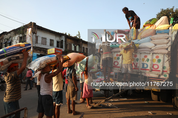 Labourers load consumer goods onto supply trucks at a wholesale market in Kolkata, India, on November 11, 2024. India's consumer price infla...