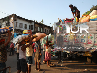 Labourers load consumer goods onto supply trucks at a wholesale market in Kolkata, India, on November 11, 2024. India's consumer price infla...