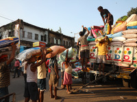 Labourers load consumer goods onto supply trucks at a wholesale market in Kolkata, India, on November 11, 2024. India's consumer price infla...