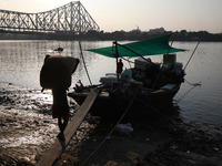 A laborer carries consumer goods to load onto a supply boat on the banks of the river Ganges at a wholesale market in Kolkata, India, on Nov...