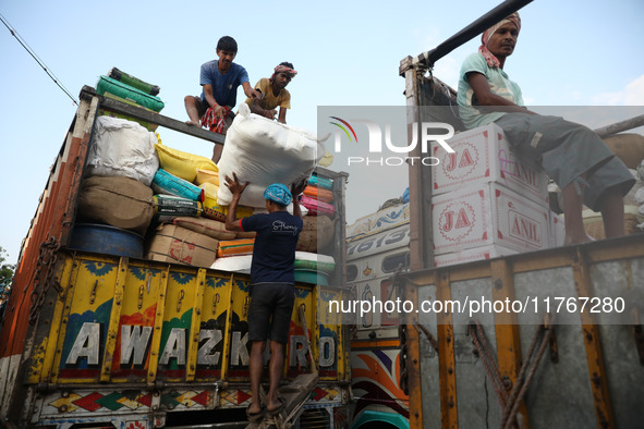 Labourers load consumer goods onto supply trucks at a wholesale market in Kolkata, India, on November 11, 2024. India's consumer price infla...