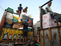 Labourers load consumer goods onto supply trucks at a wholesale market in Kolkata, India, on November 11, 2024. India's consumer price infla...