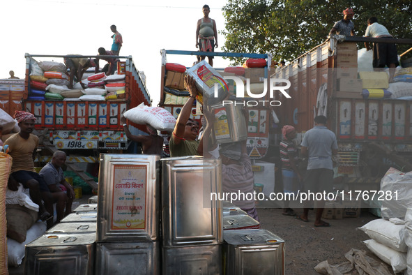 Labourers load consumer goods onto supply trucks at a wholesale market in Kolkata, India, on November 11, 2024. India's consumer price infla...