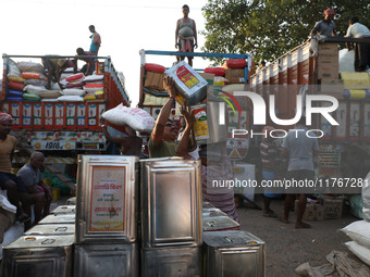 Labourers load consumer goods onto supply trucks at a wholesale market in Kolkata, India, on November 11, 2024. India's consumer price infla...