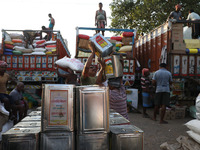 Labourers load consumer goods onto supply trucks at a wholesale market in Kolkata, India, on November 11, 2024. India's consumer price infla...