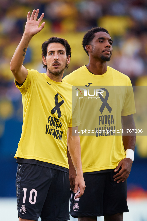 Dani Parejo of Villarreal CF wears a t-shirt supporting the victims of the Valencia floodings and waves his hand next to his teammate Logan...