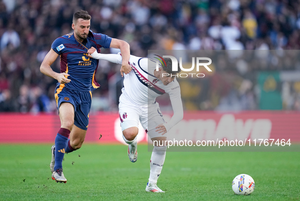 Bryan Cristante of AS Roma and Santiago Castro of Bologna FC compete for the ball during the Serie A Enilive match between AS Roma and Bolog...