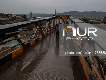 People walk on a bridge during rainfall in Baramulla, Jammu and Kashmir, India, on November 11, 2024. (